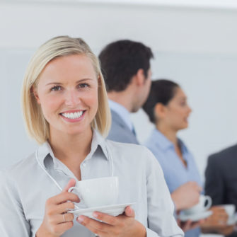 Businesswoman wearing lanyard smiling at camera at conference