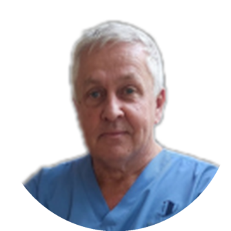 Bobby Watson wearing blue scrubs with gray hair, a neutral facial expression, against a light background
