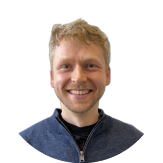 Fearghas Lafferty smiling portrait; blonde hair, blue zip jumper, neutral background