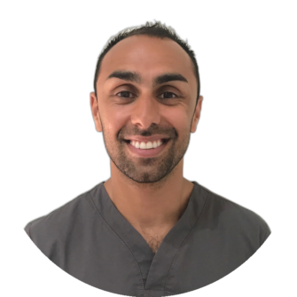 Portrait of a dental professional in grey scrubs with a friendly smile, head-and-shoulders shot against a white background